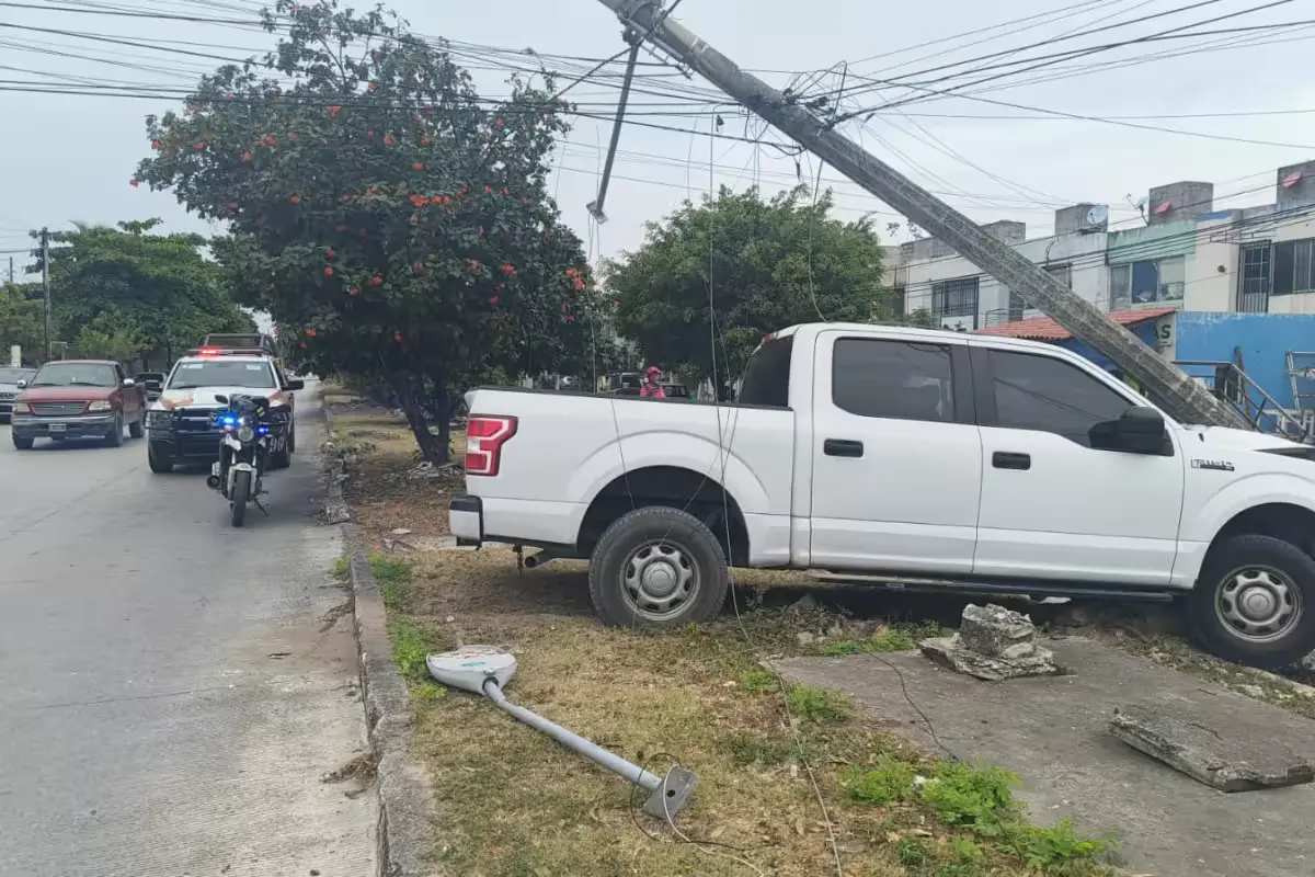 A white Ford pickup truck with front-end damage crashed into a Telmex telephone pole on a Cancun street.