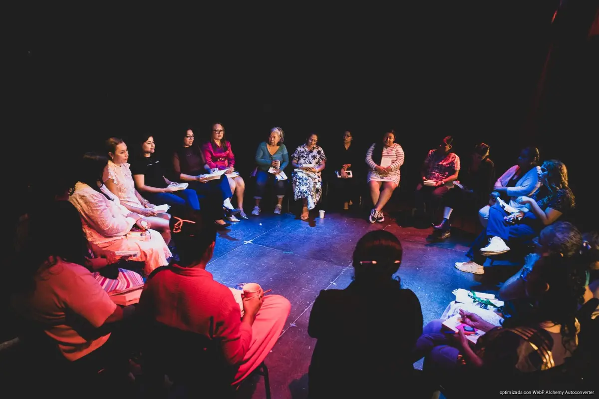 Women gathered around a table reading books at the HA Women's Reading Circle in Playa del Carmen