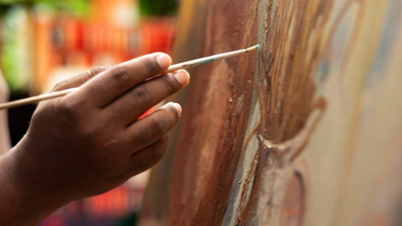 Young artists painting a community mural in Villas Otoch Paraíso, Cancún
