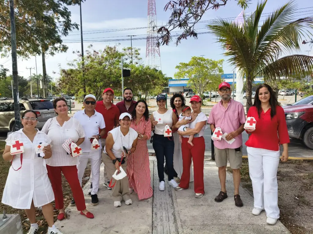 Members of the Association of Public Relations of the Mexican Caribbean (ARPCM) holding donation jars during a Red Cross collection drive in Cancun.