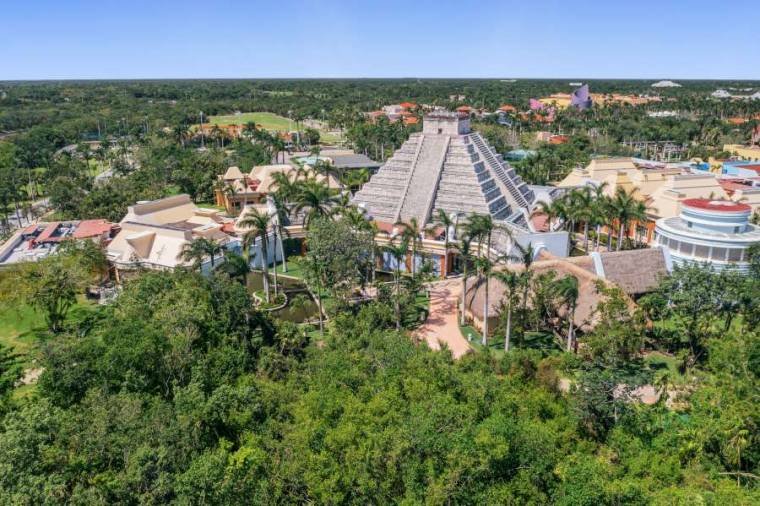 Aerial view of a beachfront resort with turquoise water and palm trees in Riviera Maya, Mexico