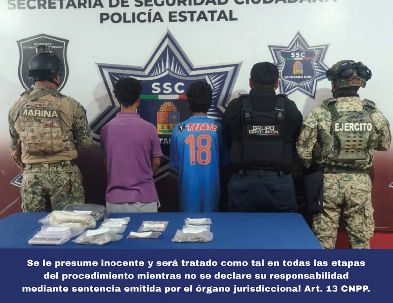 Police officers standing next to evidence bags containing suspected drugs during a press presentation in Cancun
