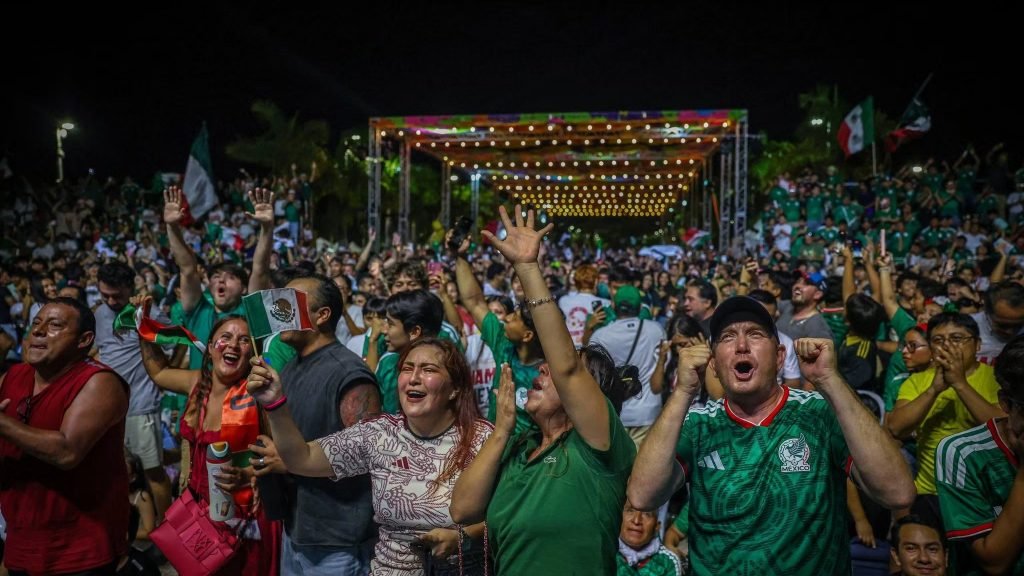 Large crowd gathered at Cancun Fut Fest watching a World Cup match on a giant screen