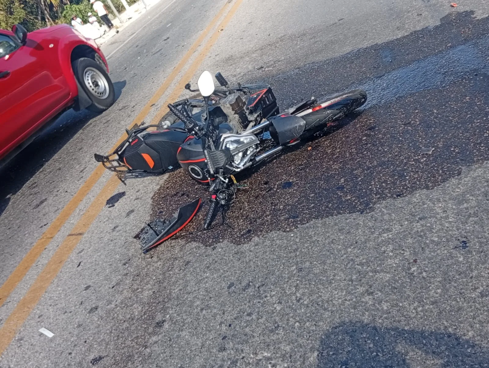 Emergency responders at the scene of a motorcycle accident on a highway in Cancun