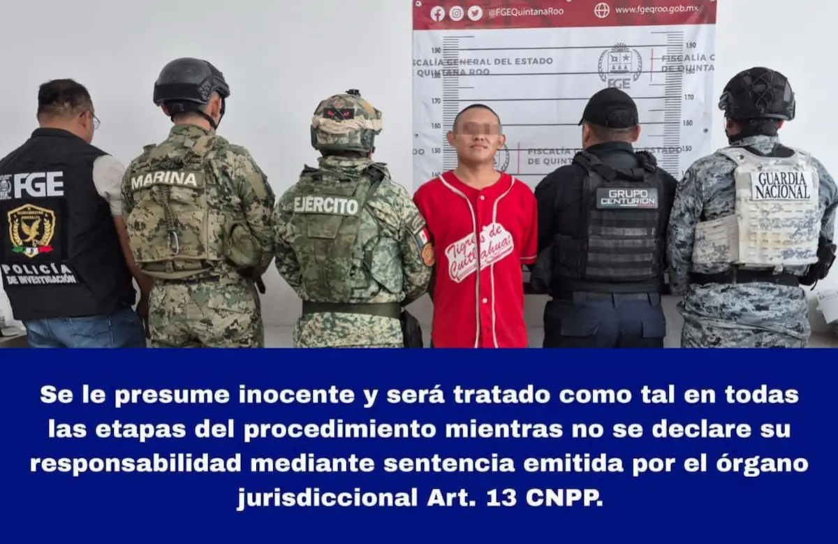 Police officers detain a man on a street in Cancun
