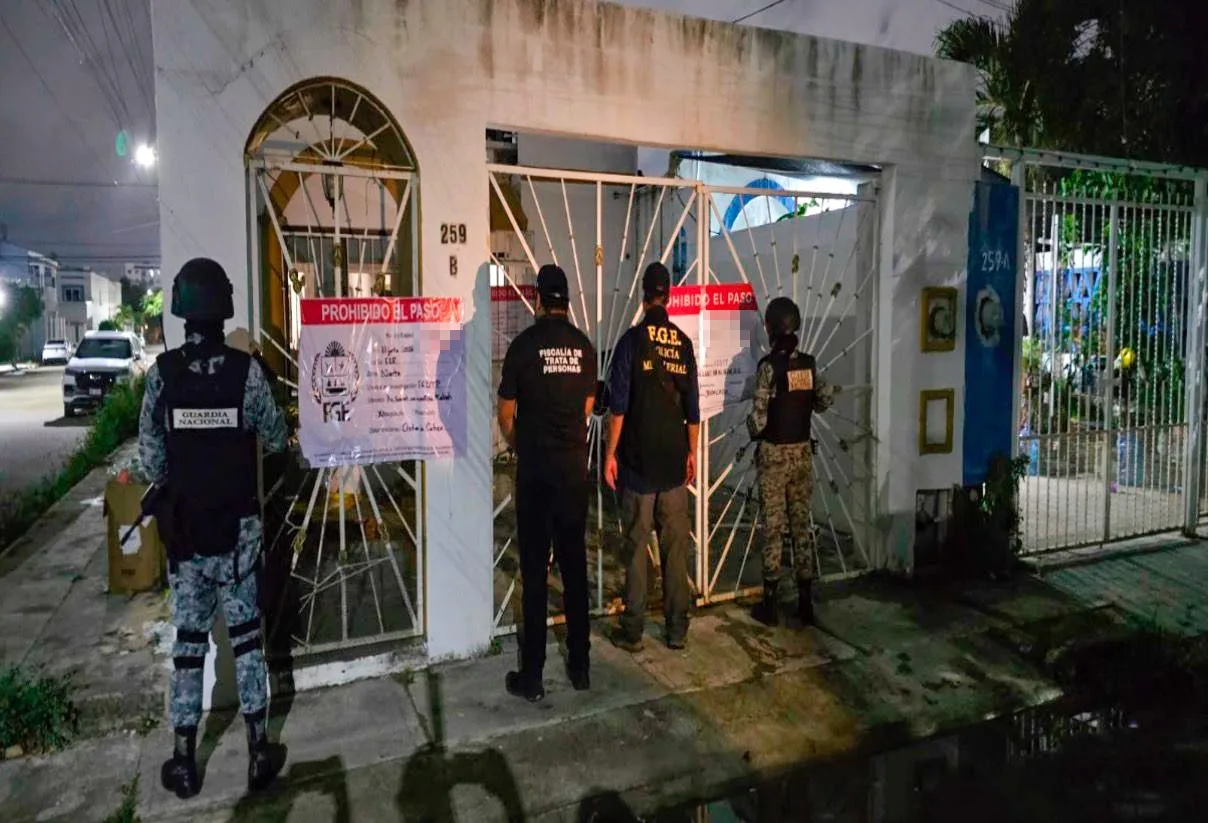 Police officers and National Guard agents outside a raided property in Cancun