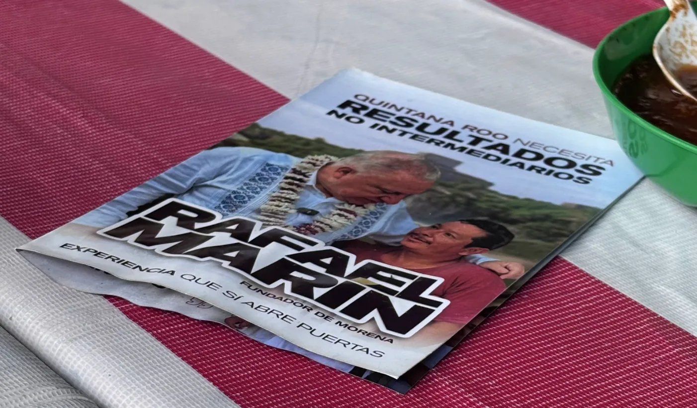 A busy street market in Cancun with political flyers and a booth