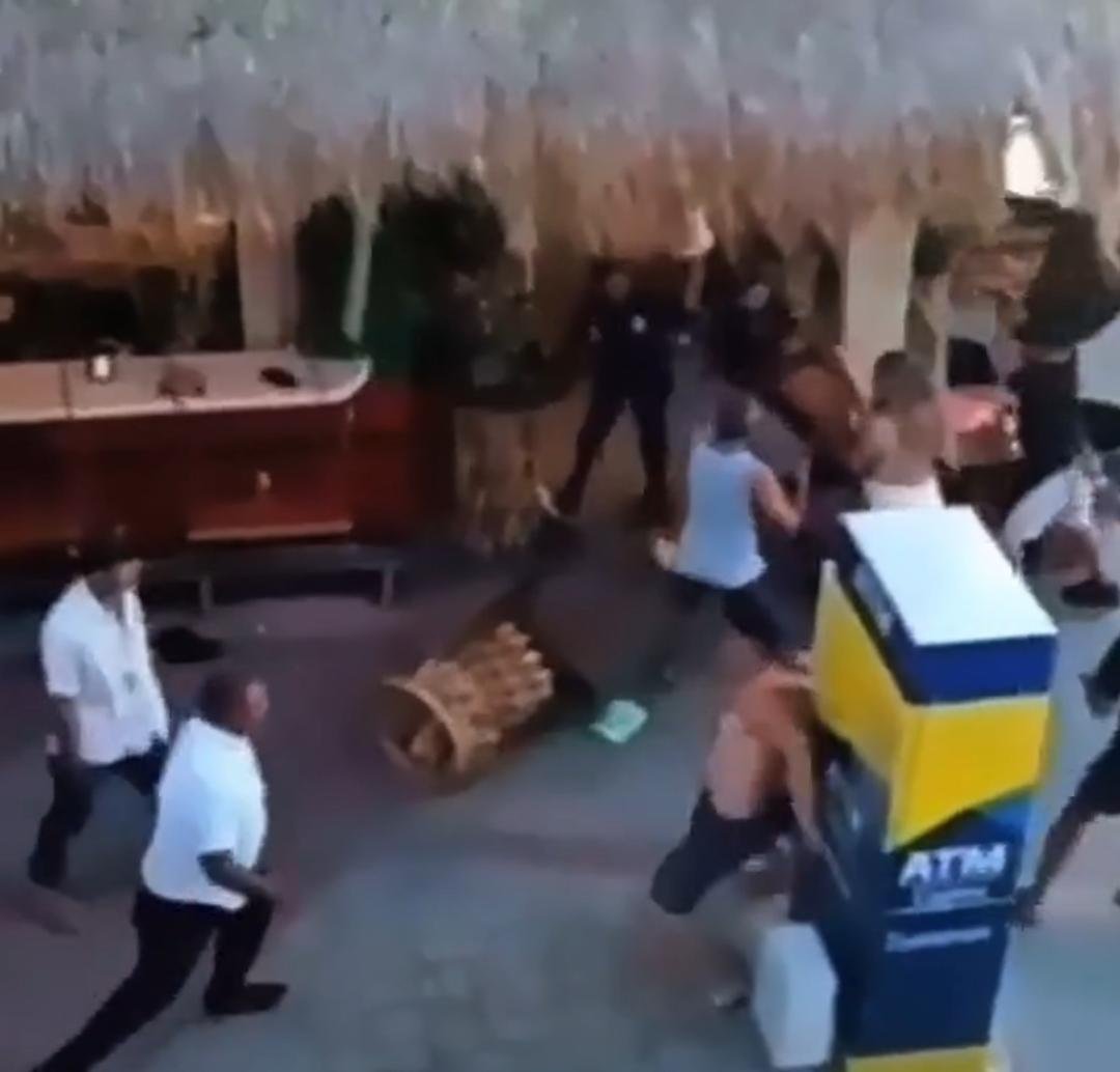 Police officers intervene in a brawl between tourists and restaurant staff in Cozumel's tourist zone.
