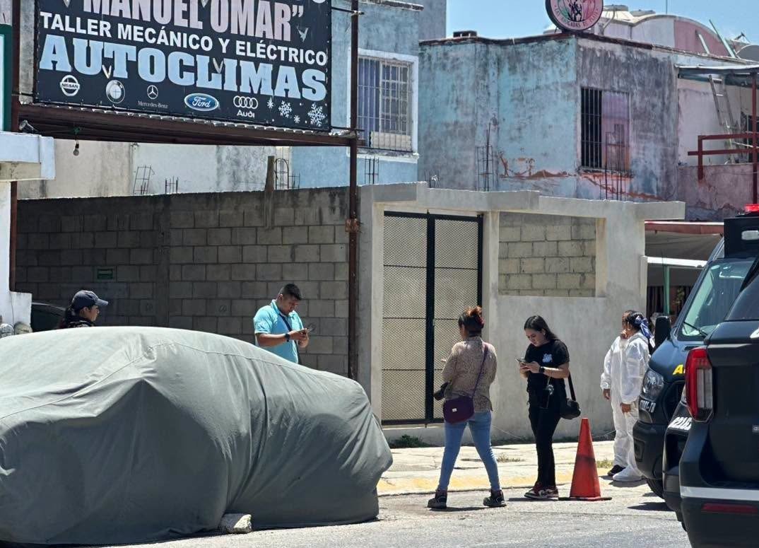 Police officers and forensic investigators at a mechanic's shop in Playa del Carmen after a fatal shooting