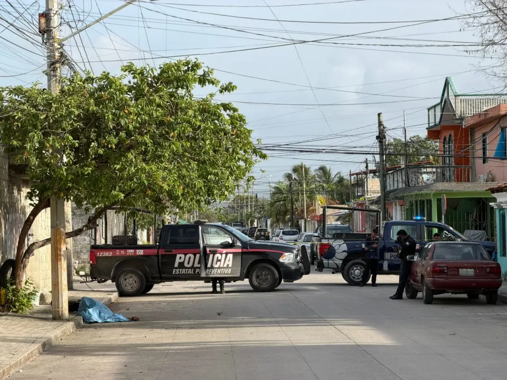 Police officers cordon off a street in Cancun's Region 100 where a man's body was found with signs of violence.