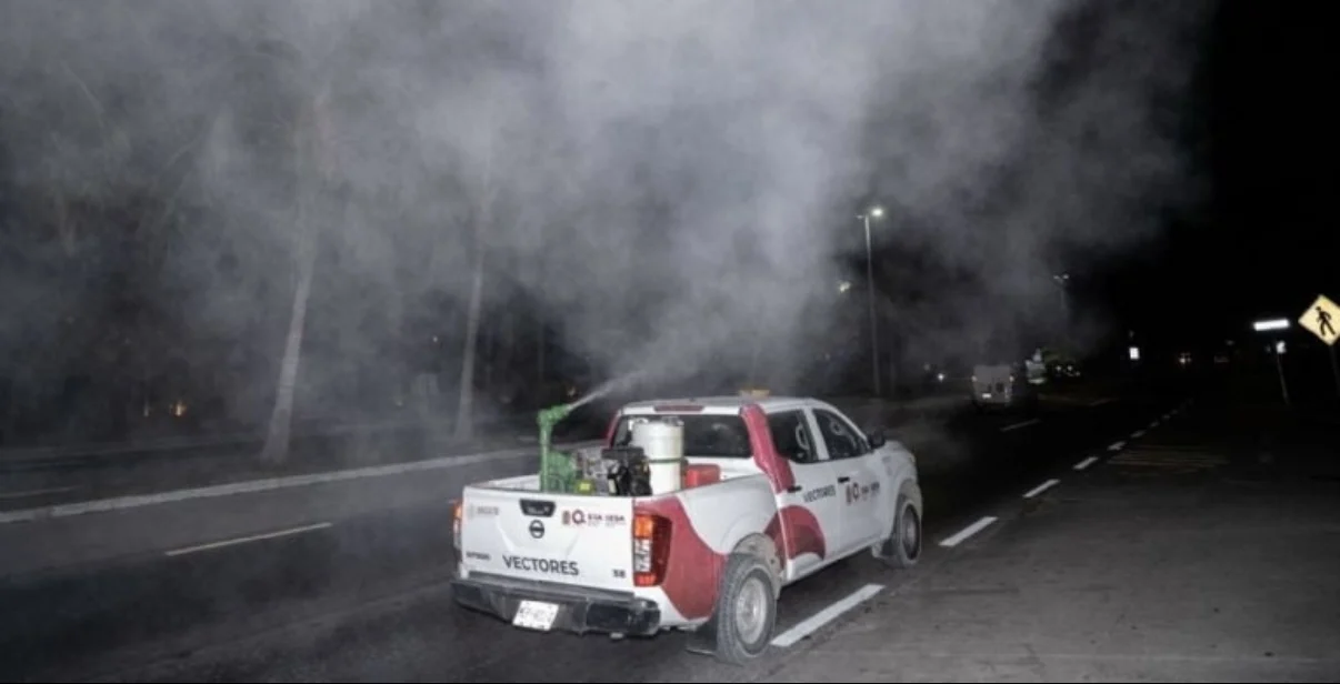 A health worker fumigating a residential area in Quintana Roo to control dengue mosquitoes