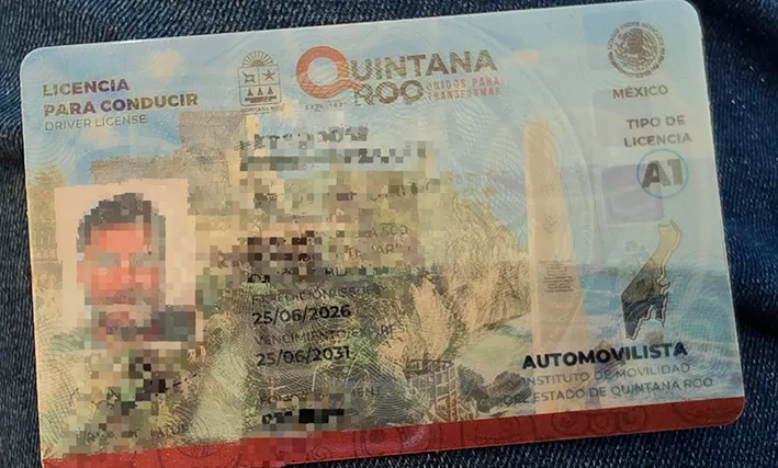 A driver's license card placed on a wooden table