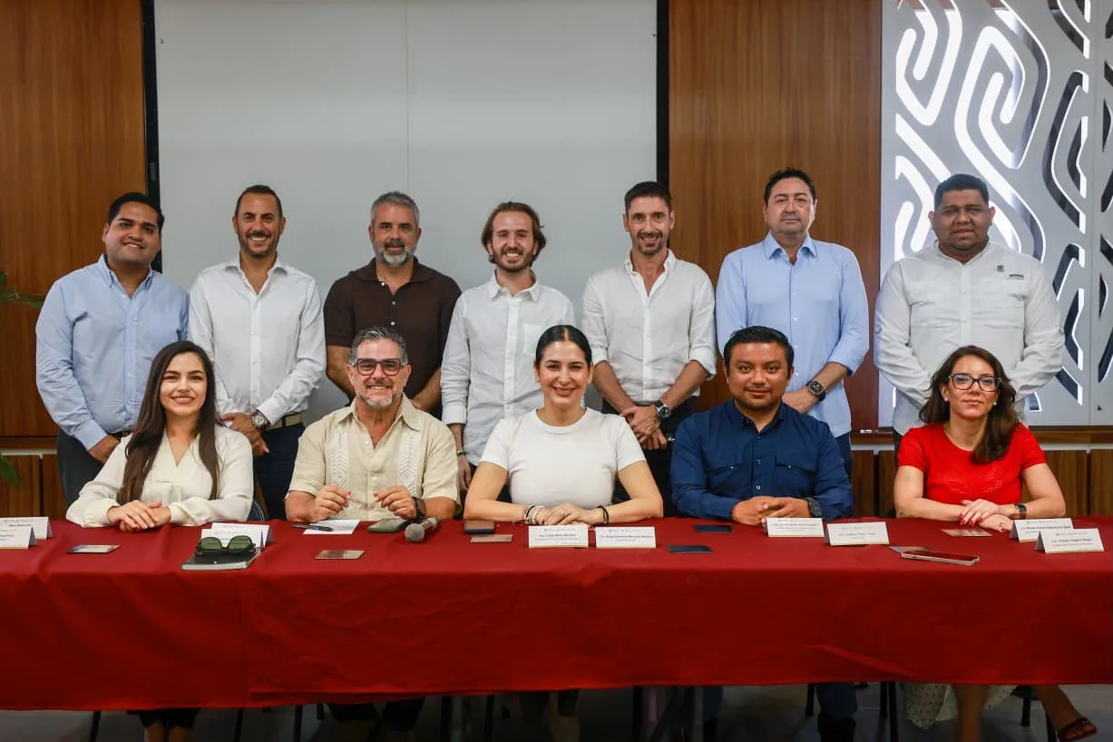 Mayor Estefanía Mercado seated at a meeting table with hotel and business representatives discussing sargassum cleanup.
