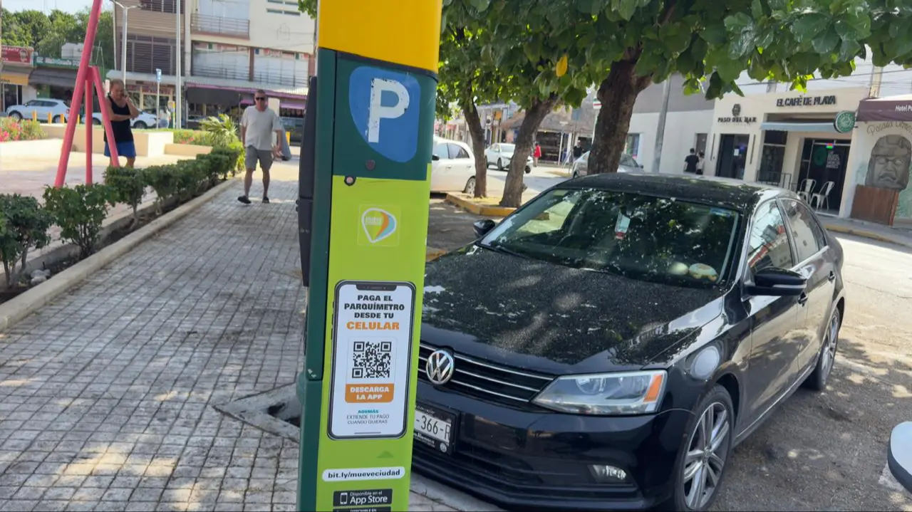 A parking meter in Playa del Carmen showing an error message, with a car parked nearby.