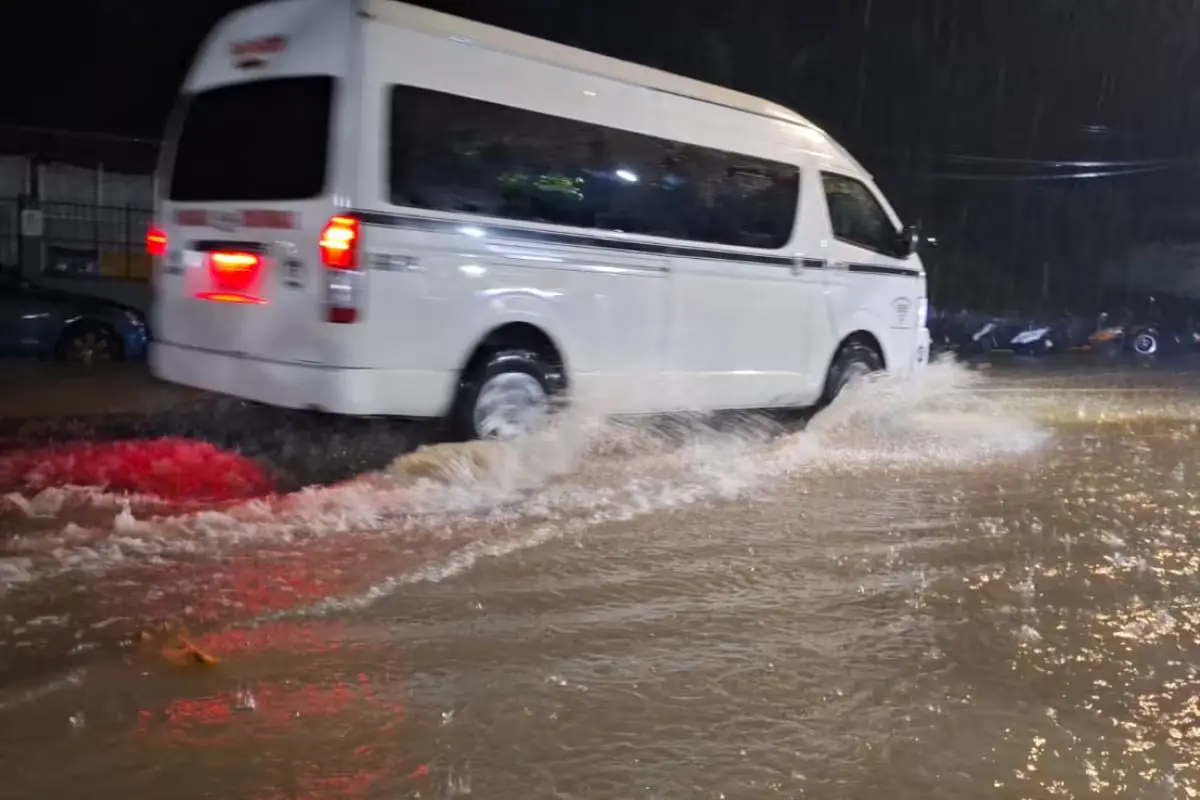 A flooded street in Felipe Carrillo Puerto with water nearly reaching the sidewalk level