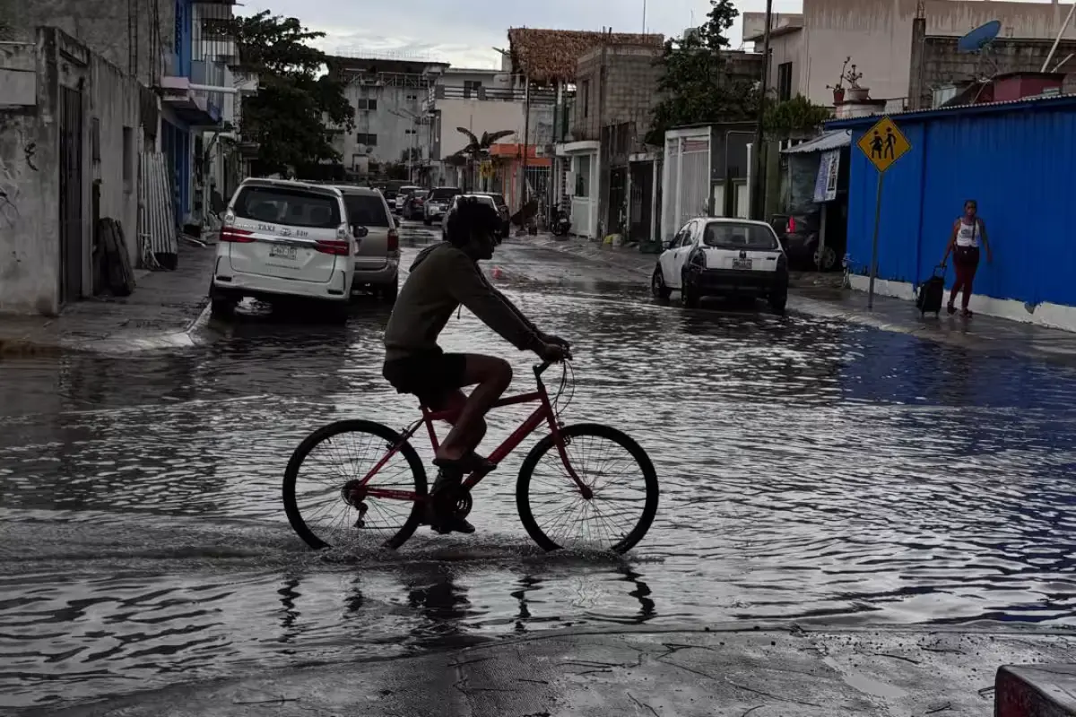 A flooded street in Playa del Carmen with water covering the road and sidewalks