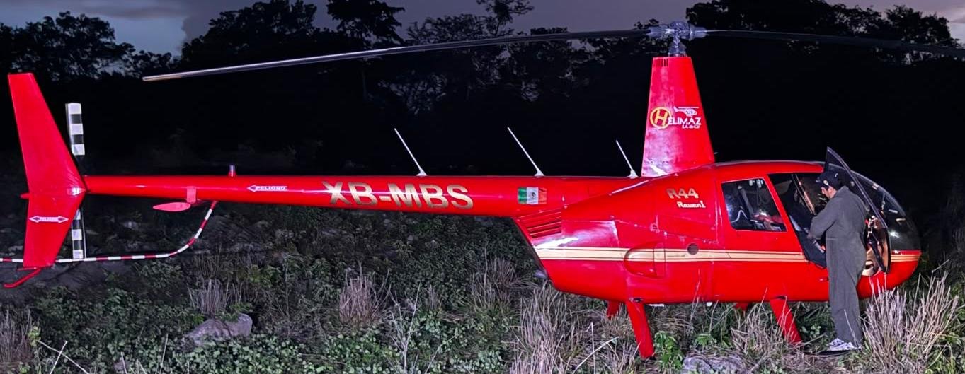 A red helicopter on the ground near the Ek Balam archaeological zone in Yucatan after an emergency landing