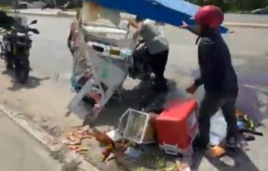 A tricycle lies overturned on the side of Highway 307 near Puerto Aventuras, with scattered merchandise around it.