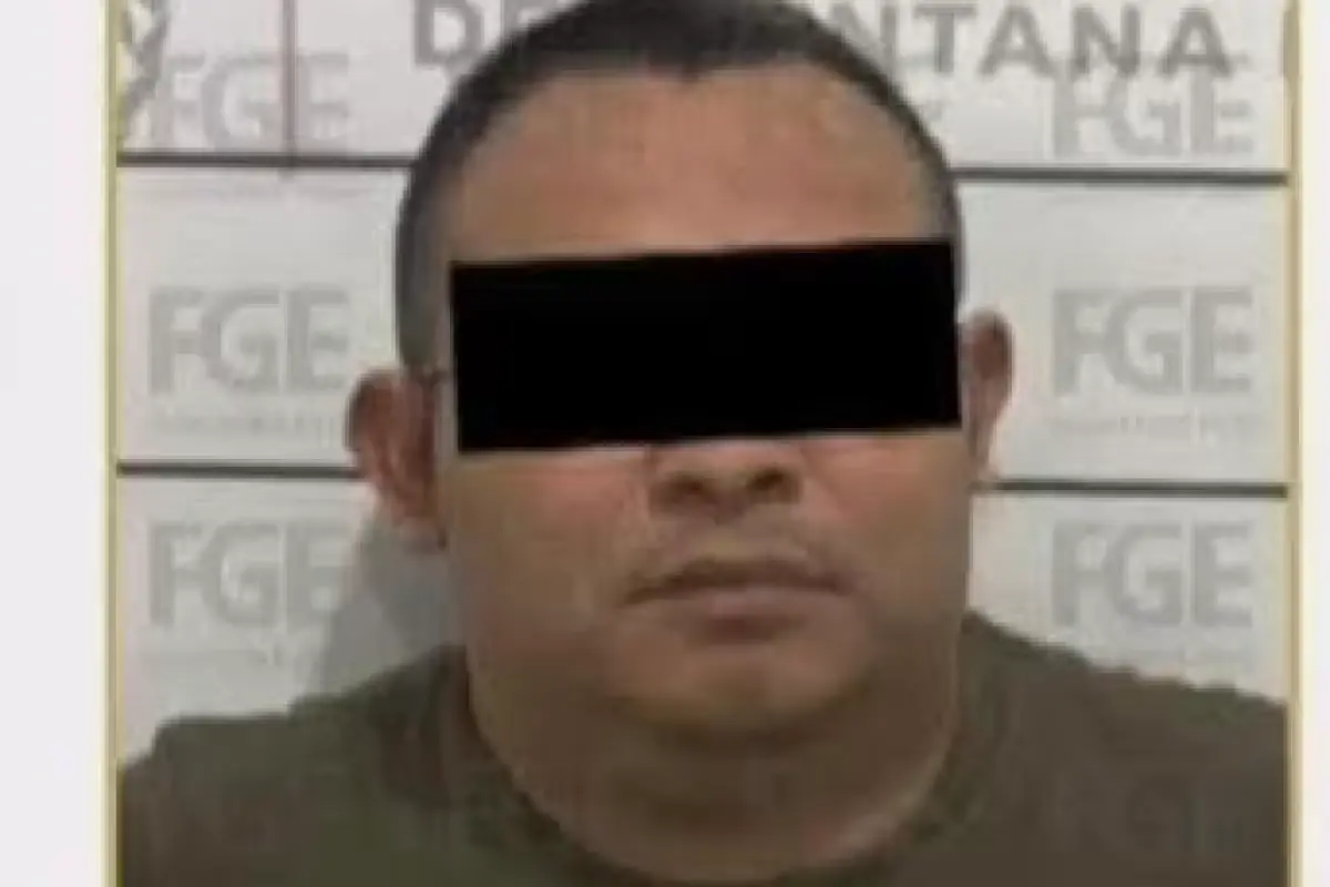 A man in handcuffs being led by police officers in Tulum, Quintana Roo
