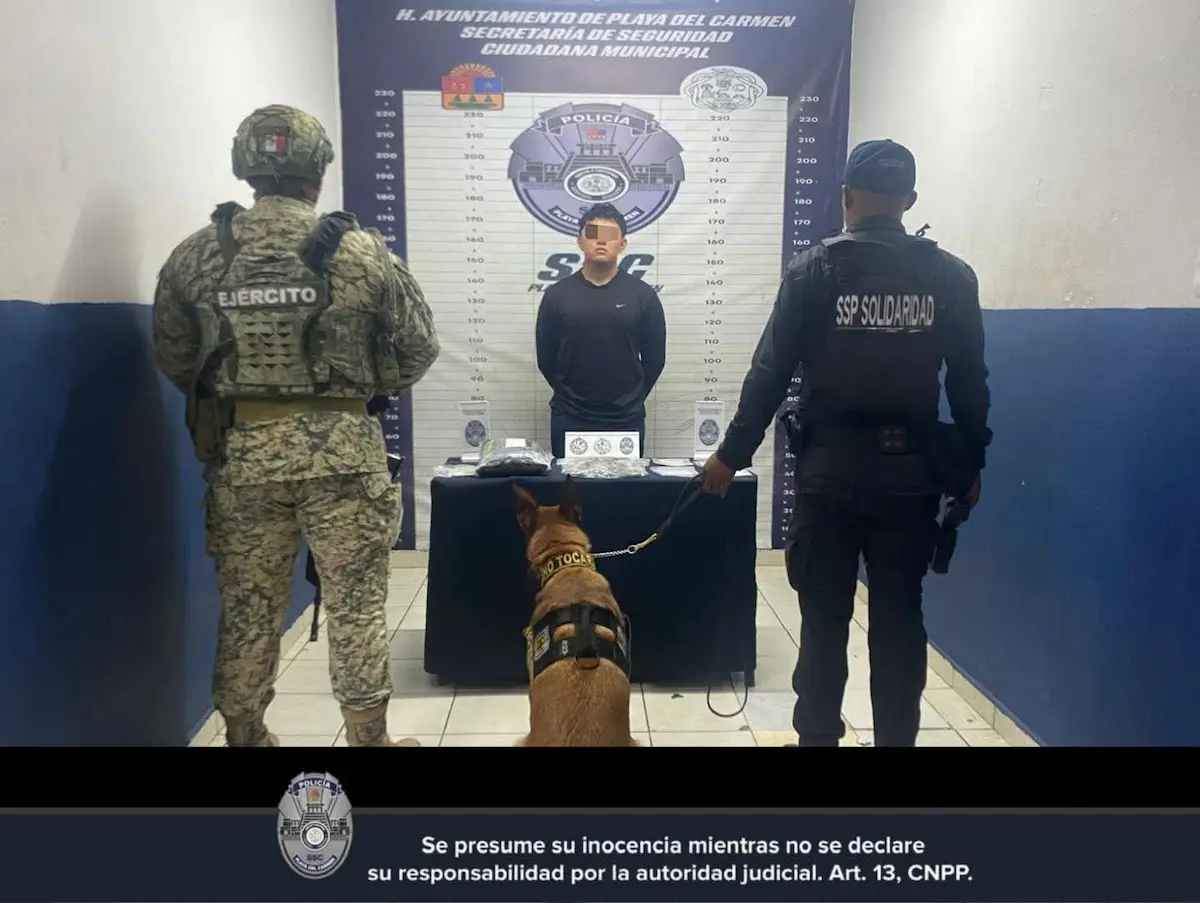 Police officers and soldiers detain a young man on a street in Playa del Carmen