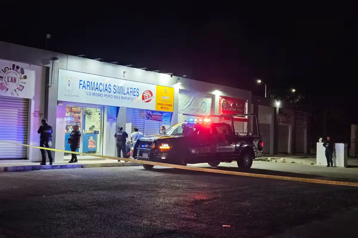 Police officers cordon off the parking area outside a pharmacy in Cancun where a teenager died.