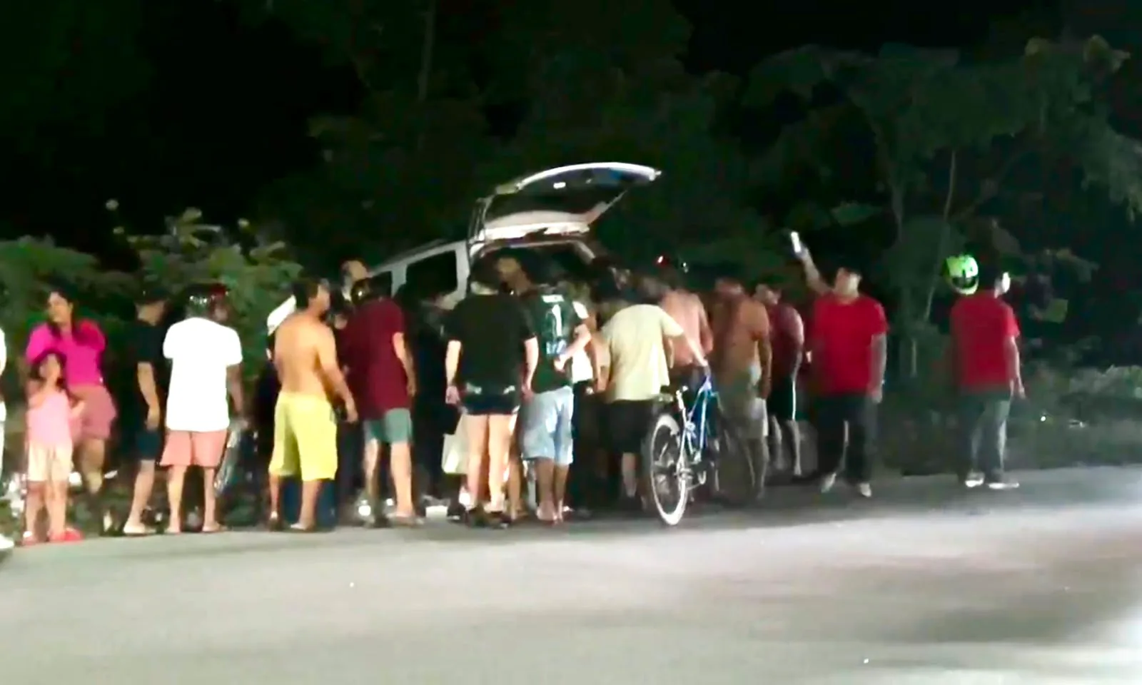 Police officers detain a man next to a damaged car on a street in Playa del Carmen