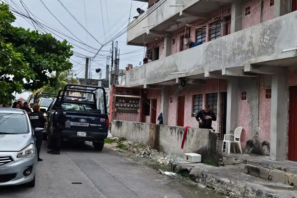 Police officers cordon off a street in Cancun after a shooting at a rooming house