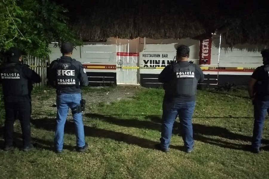 Police officers standing outside a house during a drug raid in Quintana Roo