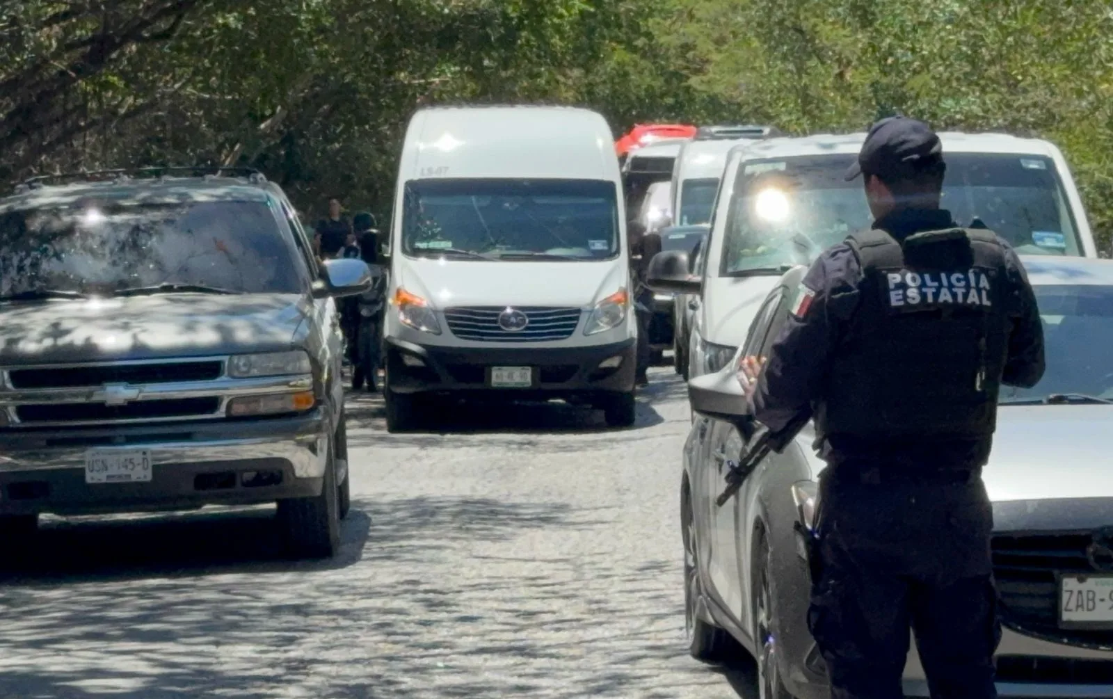 Police vehicles on a street in Cancun during a search operation for armed men in a blue GMC truck