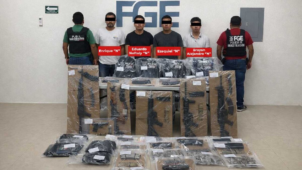 Police officers with seized weapons and drugs during a drug bust in Quintana Roo