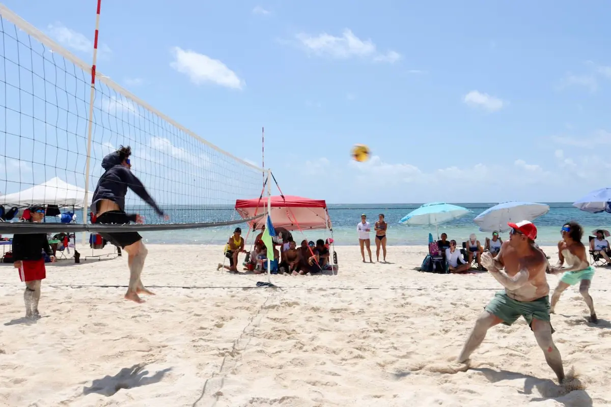A clean beach in Puerto Morelos with minimal sargassum on the sand and turquoise water.