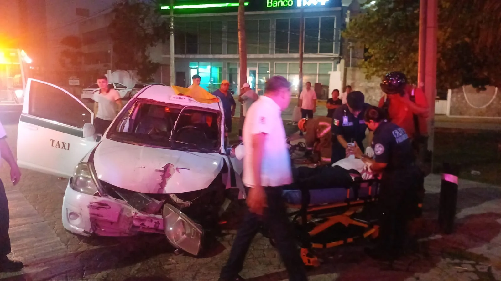 Rescuers using hydraulic equipment to free a trapped taxi driver from a damaged vehicle on Bonampak Avenue in Cancun