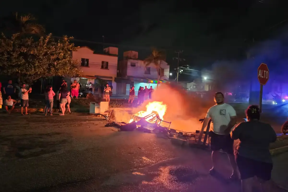 Residents block 20 de Noviembre avenue with burning wooden objects during a protest over power outage in Cancun