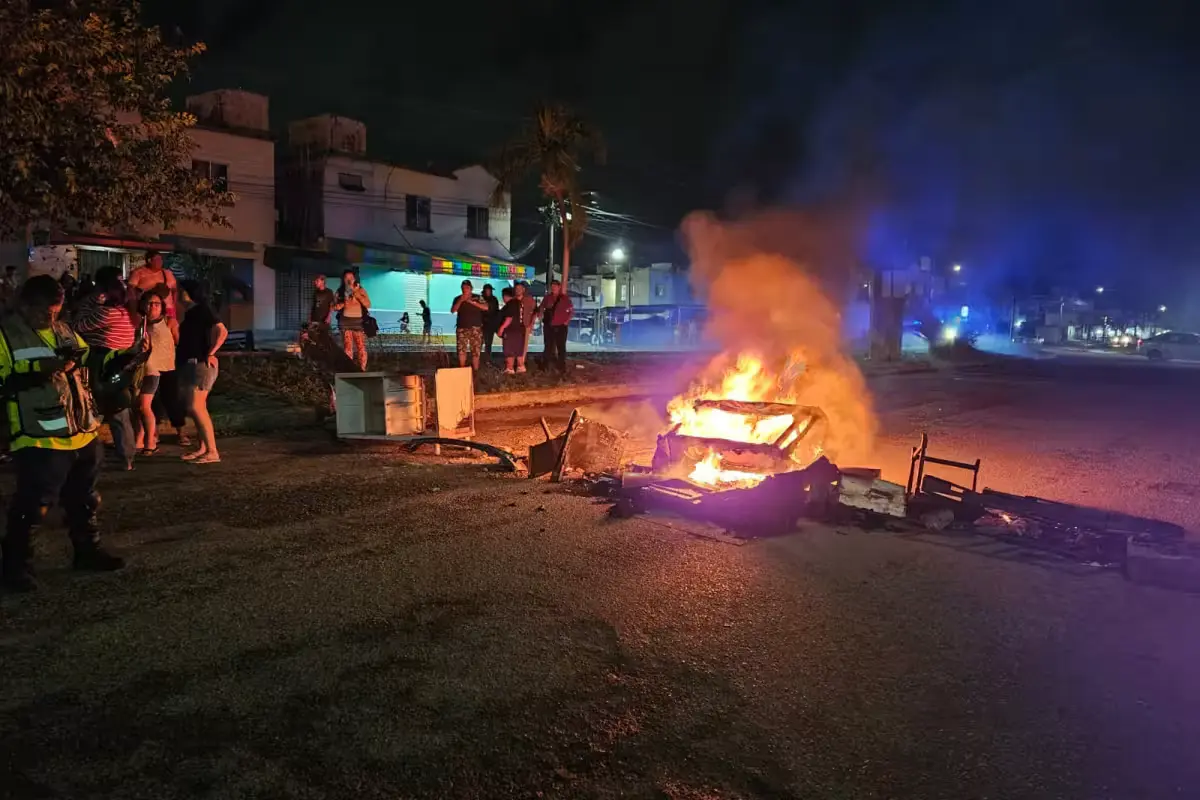 Residents burning objects on a road to block traffic during a protest over a power outage in Cancun