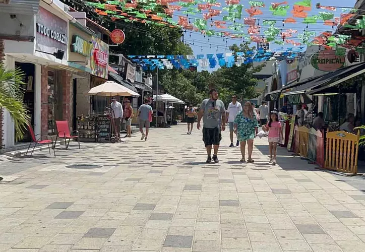 A small hotel in Playa del Carmen with empty beach chairs and sargasso seaweed on the shore