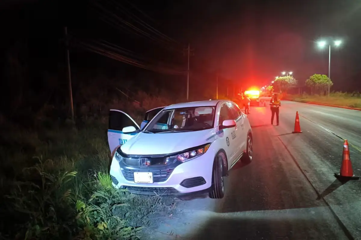 A taxi abandoned on the side of the Cancun-Puerto Morelos highway near the Royalton hotel, where the driver's body was found.