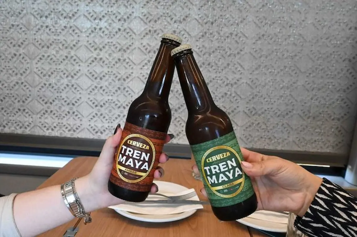 Tren Maya train with a craft beer bottle in foreground