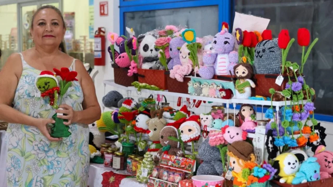 Women entrepreneurs displaying handmade jewelry and crafts at a market stall in Cozumel