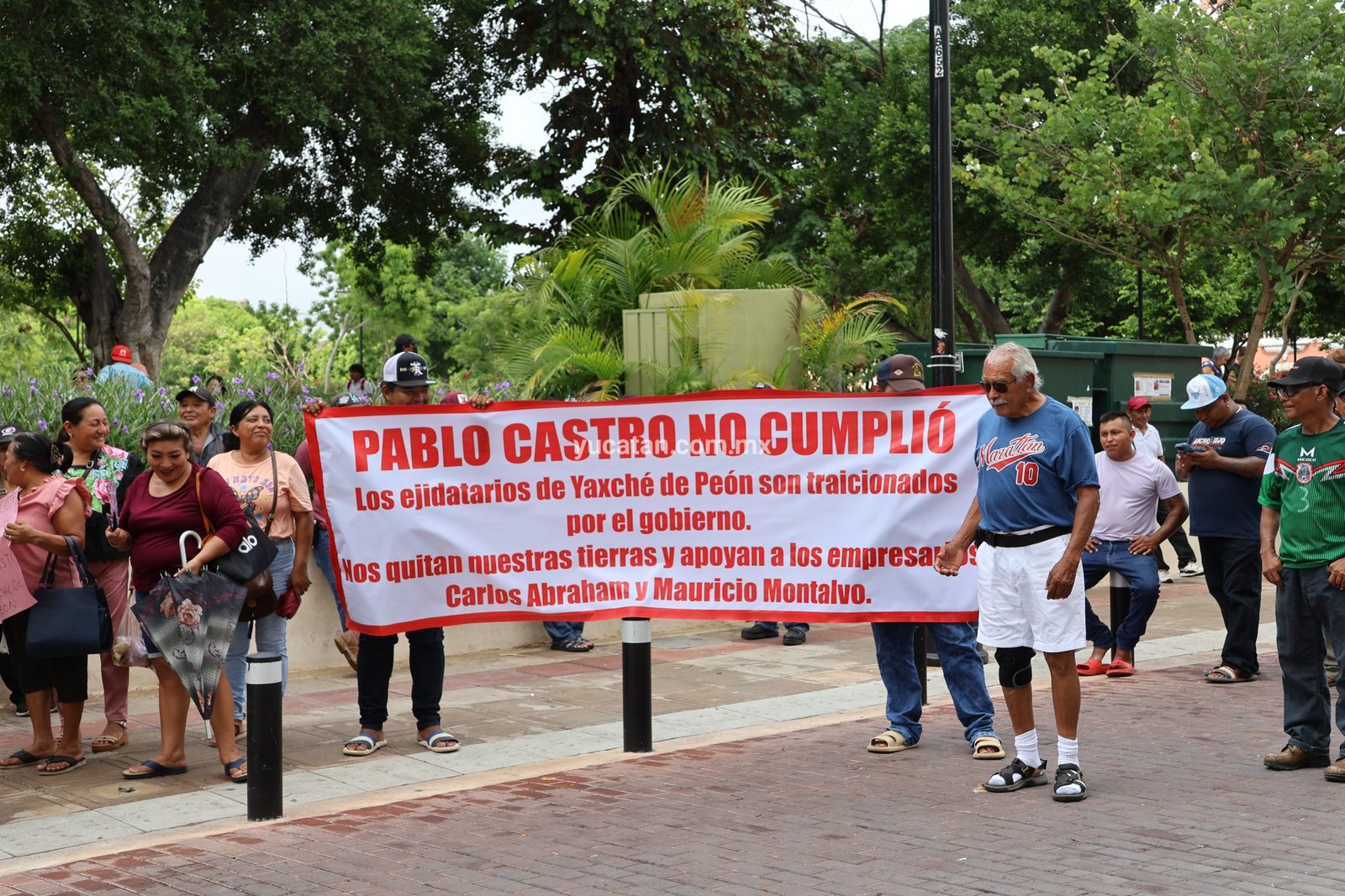 About 50 residents of Yaxché protest in front of the Government Palace in Mérida, holding signs demanding compensation for Tren Maya impacts.