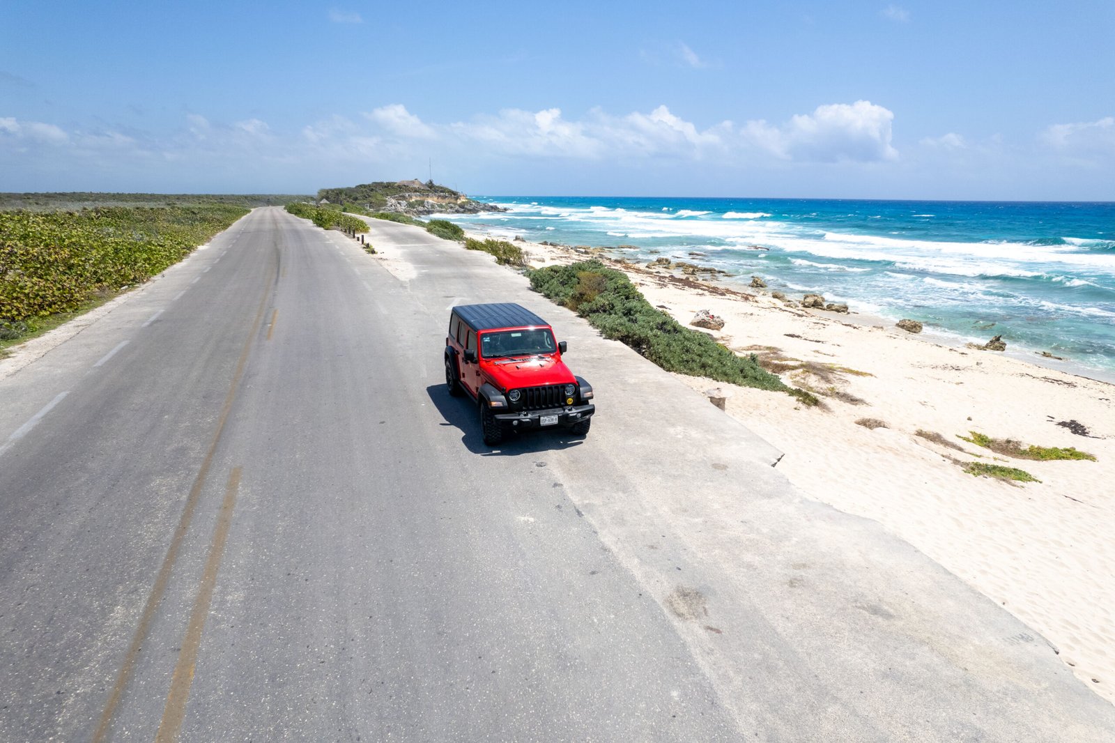 a jeep on a beach road in cozumel