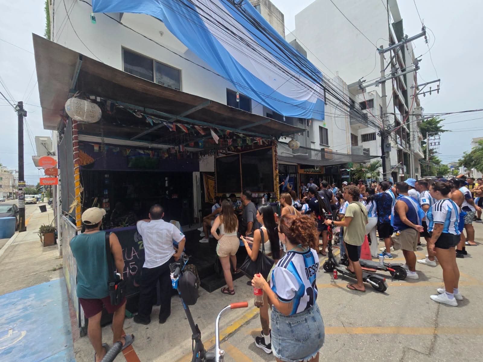 Argentine fans cheering and waving flags on a street in Playa del Carmen after their World Cup win