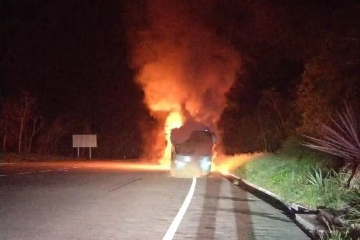 A burnt passenger bus on the shoulder of a highway near Playa del Carmen, Quintana Roo