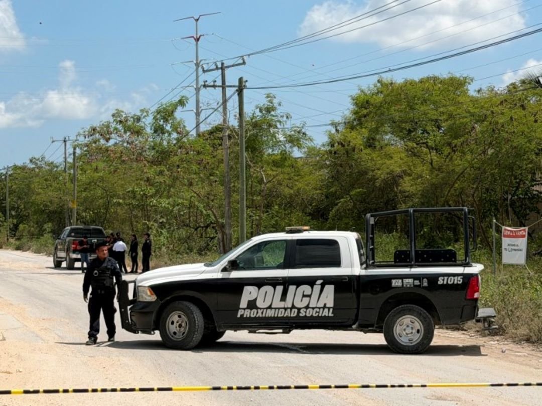 Police and forensic investigators at the scene where a body was found inside a pickup truck on Cancun's Arco Vial.