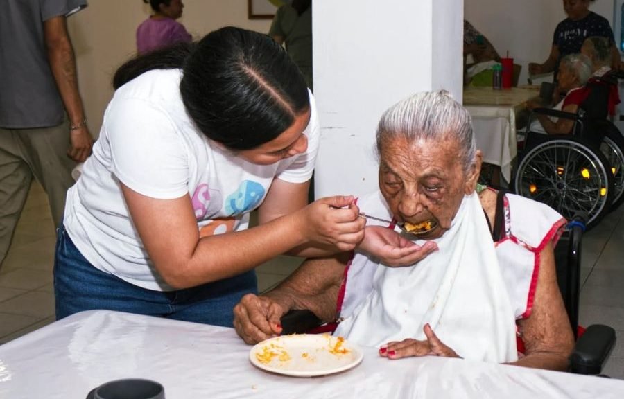 A caregiver assisting an elderly person in Cancun