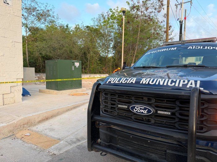 Police tape cordoning off a crime scene on a Cancun street near a construction site