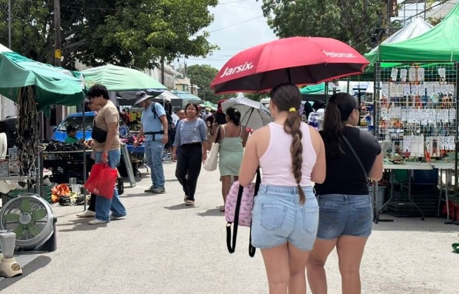 People seeking shade under a palapa on a sunny beach in Cancún