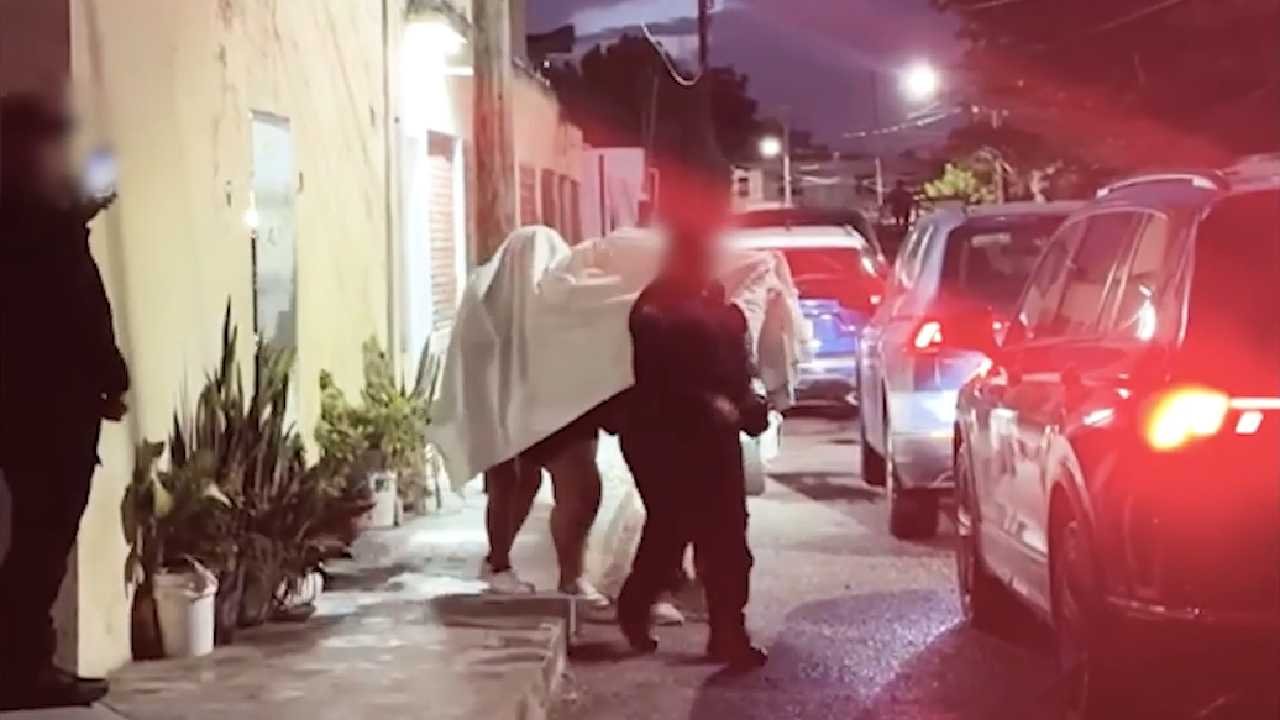 Police officers outside a hotel in Cancun during a raid that rescued four women from sex trafficking