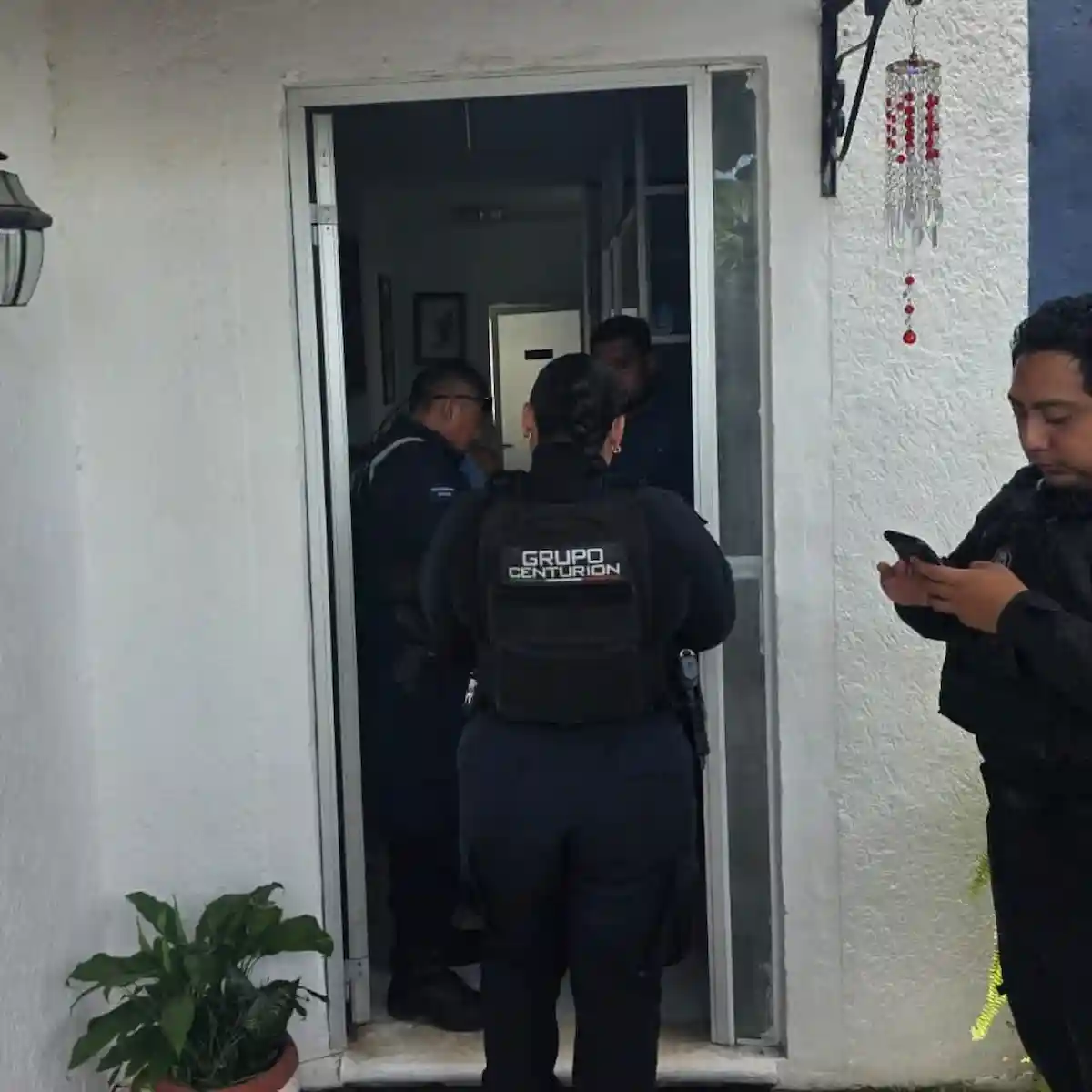 Grupo Centurión police officers with rescued adults after foiling a phone extortion attempt in Cancún