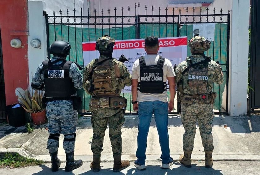 Police officers at a house in Cancun's Region 528 after a raid linked to loan sharking and drug possession.