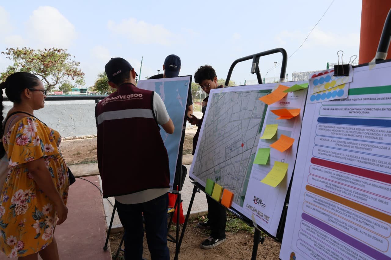 Residents at a public consultation event in Cancun discussing mobility issues with officials from IMOVEQROO.